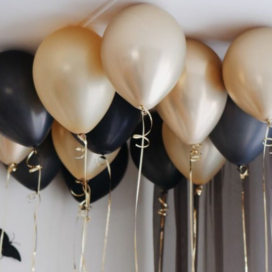 Ceiling balloons in black and gold foil ribbon inflated with helium